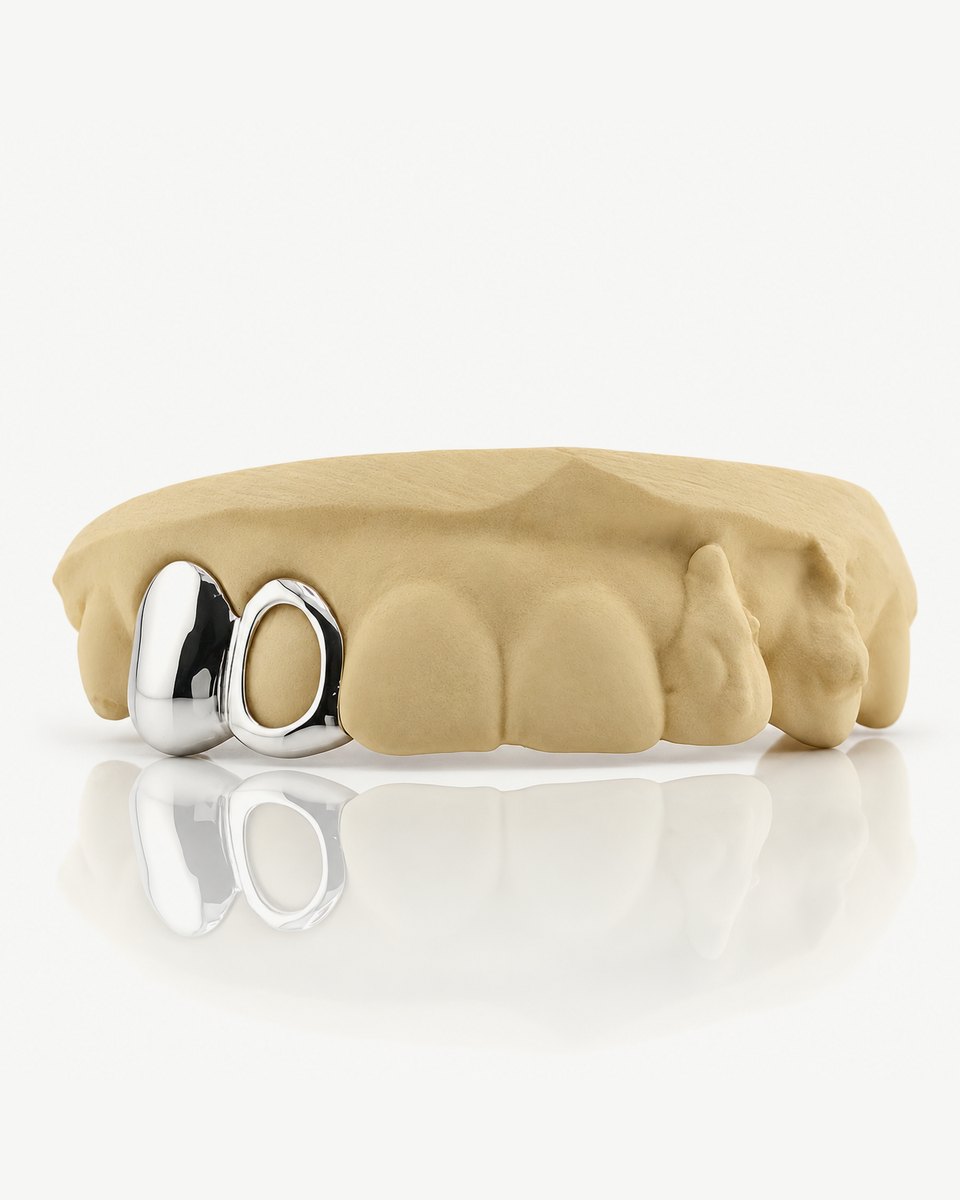 Bộ grillz 2 răng bằng bạc 925 để trần, một răng bọc kín và một răng viền hở, gắn trên mẫu răng