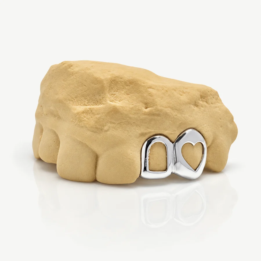 Bộ grillz 2 răng bạc 925 để trần, một răng viền hở và một răng khoét trái tim, trên mẫu răng